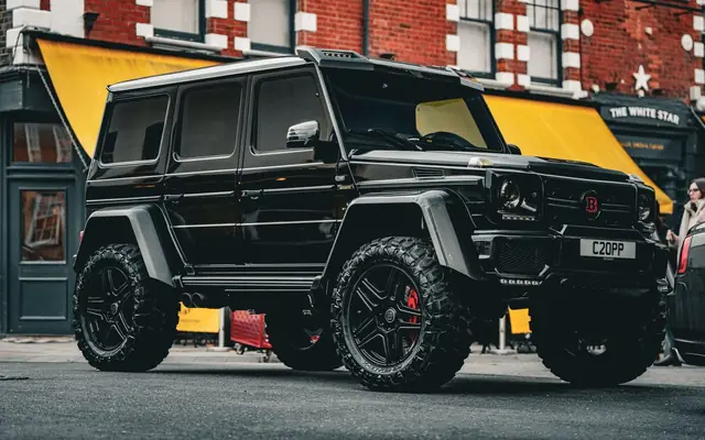 A powerful black Mercedes SUV parked in a vibrant urban area.