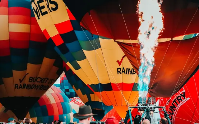 Colorful hot air balloons inflating with flames, capturing festival excitement in Albuquerque.