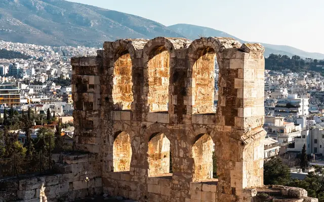 View of the ancient Odeon of Herodes Atticus in Athens with a cityscape backdrop.