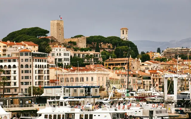 Beautiful harbor scene in Cannes showcasing historic buildings and vibrant waterfront activities.