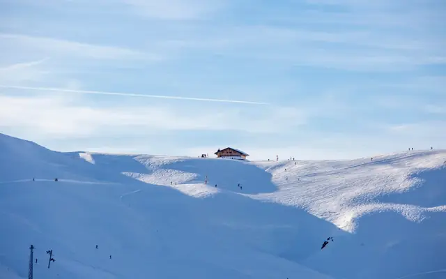 Stunning winter landscape of Les Contamines-Montjoie ski resort in France with skiers on snowy slopes.