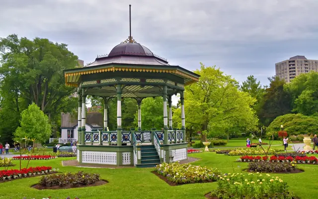 Green gazebo amidst colorful flower beds in Halifax Public Gardens.
