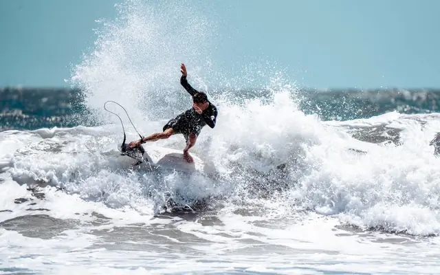A surfer skillfully riding a wave at the beach in Jacksonville, Florida.