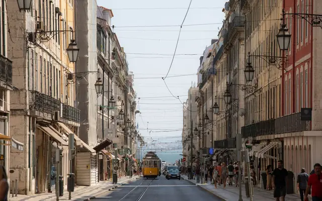 A bustling day in Lisbon featuring historic architecture and the classic yellow tram.