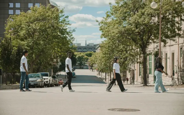 Diverse group walking on an urban street in Milwaukee, WI, during a sunny day.