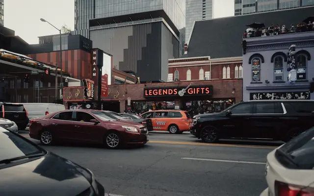 Dynamic city street view in Nashville with colorful buildings, cars, and bustling activity.