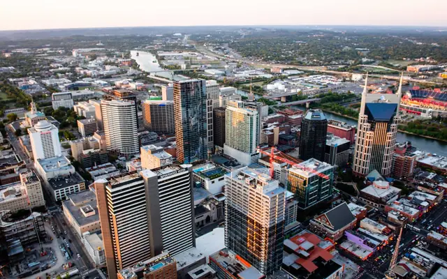Stunning aerial cityscape of Nashville, Tennessee featuring skyscrapers and urban layout at sunset.