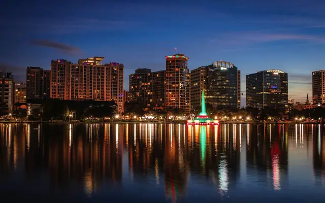 Beautiful view of Orlando skyline at dusk with reflections on Lake Eola.