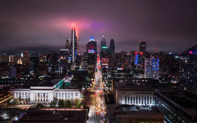 Stunning aerial view of Philadelphia's illuminated skyline at night, showcasing vibrant city lights.