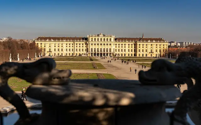 Stunning view of Schonbrunn Palace in Vienna captured from its gardens under a clear blue sky.
